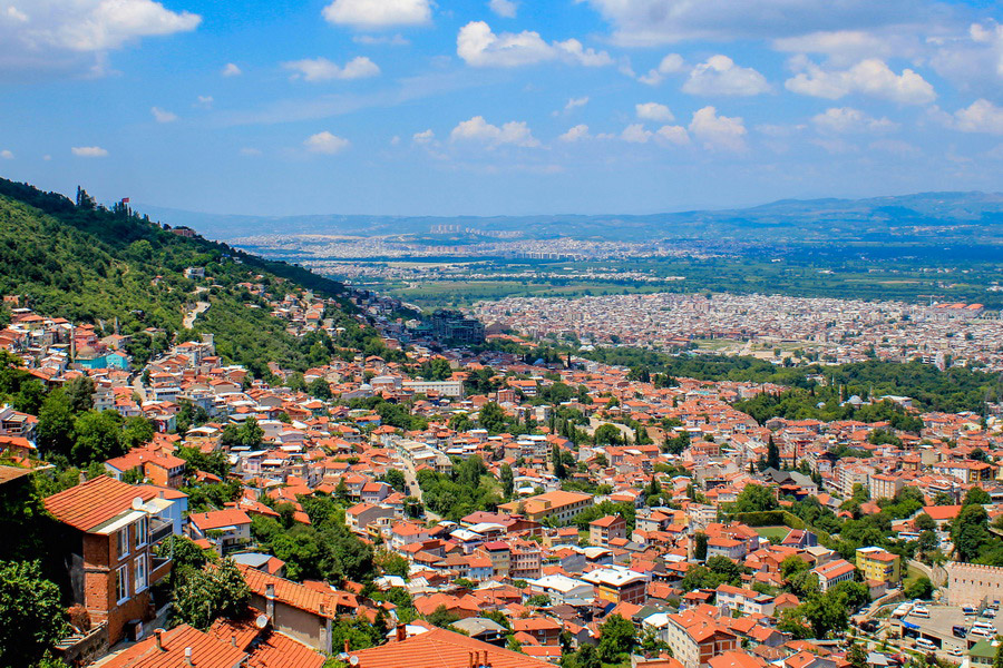 10 Best Tourist Places in Bursa for Culture & Adventure Scenic view of Bursa with historic mosques, Ottoman architecture, and lush green mountains.